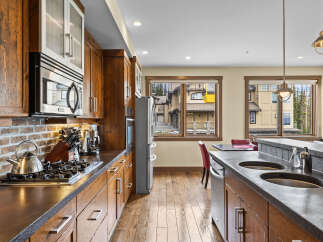 Experience luxury mountain living in this stunning kitchen featuring rich wood cabinetry and sleek stainless steel appliances.