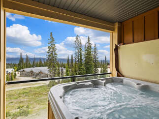 Enjoy a relaxing soak in this private hot tub with stunning mountain views.