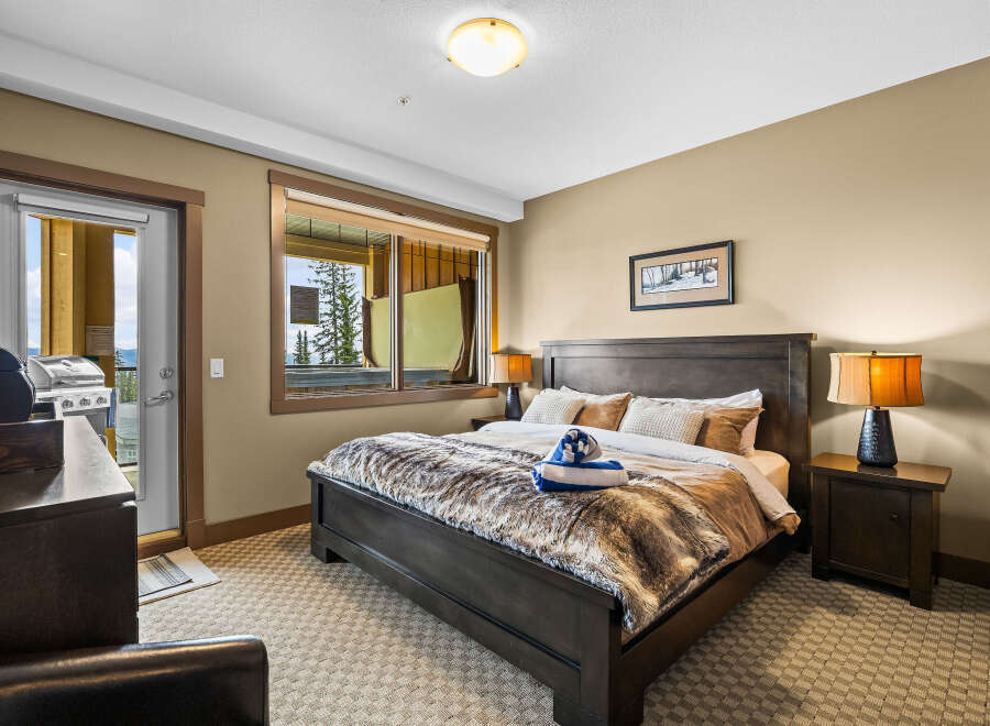 Experience ultimate comfort in this luxurious bedroom, featuring a plush king-size bed adorned with a cozy faux fur throw.