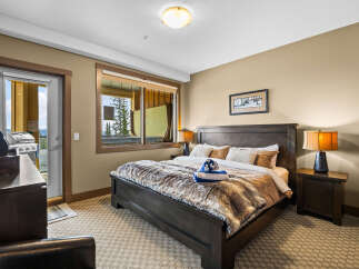 Experience ultimate comfort in this luxurious bedroom, featuring a plush king-size bed adorned with a cozy faux fur throw.