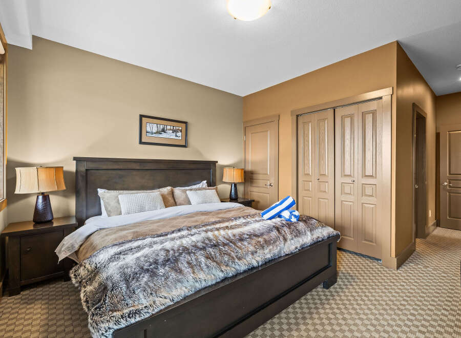 Experience ultimate comfort in this inviting bedroom, featuring a luxurious king-sized bed adorned with a plush faux fur throw.