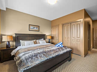 Experience ultimate comfort in this inviting bedroom, featuring a luxurious king-sized bed adorned with a plush faux fur throw.