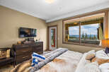 Experience ultimate relaxation in this luxurious bedroom, featuring a plush fur throw and a private balcony with a hot tub overlooking a stunning mountain vista.
