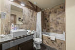 This rustic bathroom features a textured, earthy-toned wall that adds a unique charm.