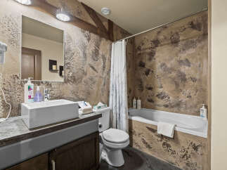 This rustic bathroom features a textured, earthy-toned wall that adds a unique charm.