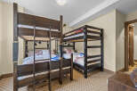 This spacious bedroom is perfect for families or groups, featuring two sets of dark wood bunk beds.