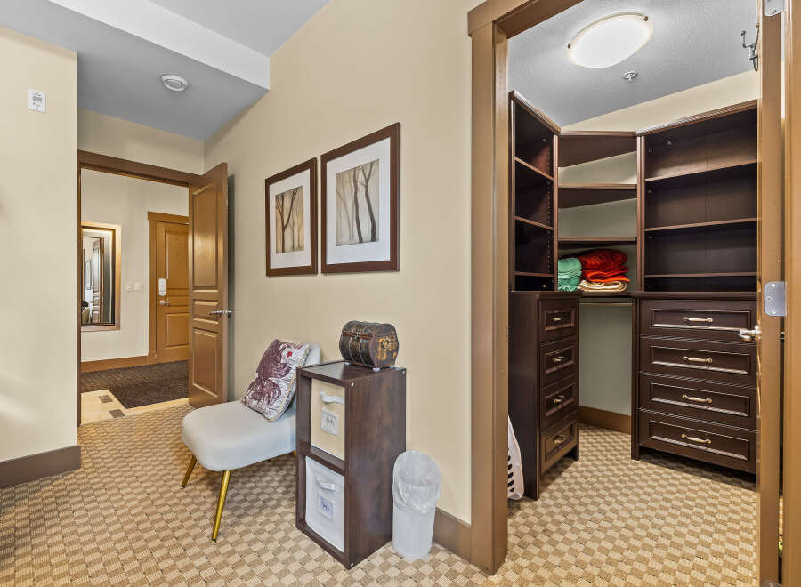 Step into this inviting hallway featuring a spacious walk-in closet with ample shelving and drawers, perfect for organizing your belongings.