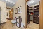 Step into this inviting hallway featuring a spacious walk-in closet with ample shelving and drawers, perfect for organizing your belongings.