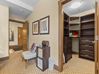 Step into this inviting hallway featuring a spacious walk-in closet with ample shelving and drawers, perfect for organizing your belongings.