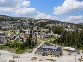 Discover this stunning mountain resort village offering a vibrant community with a mix of modern condos and chalets nestled amidst lush evergreen forests.