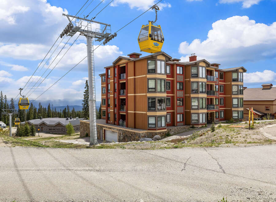 Experience mountain living in this stunning condo complex, featuring a vibrant exterior and convenient gondola access.