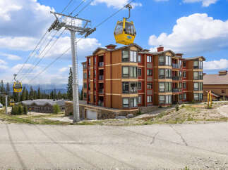 Experience mountain living in this stunning condo complex, featuring a vibrant exterior and convenient gondola access.