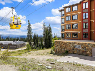 Experience the ultimate mountain lifestyle with this stunning property featuring a modern ski resort building and a scenic gondola ride.