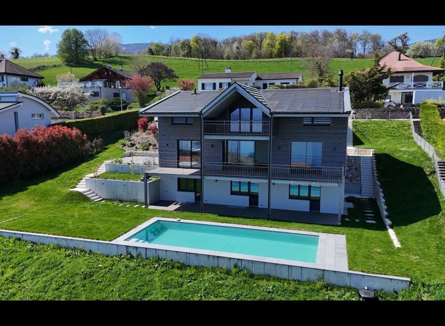 Experience modern living in this stunning hillside home featuring a sleek, contemporary design with expansive windows and multiple balconies offering breathtaking views.