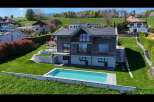 Experience modern living in this stunning hillside home featuring a sleek, contemporary design with expansive windows and multiple balconies offering breathtaking views.