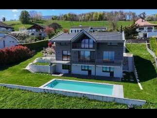 Experience modern living in this stunning hillside home featuring a sleek, contemporary design with expansive windows and multiple balconies offering breathtaking views.