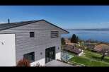Experience modern living with this stunning home featuring sleek horizontal wood siding and expansive glass doors.