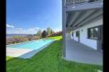 Experience modern luxury with this stunning property featuring a sleek infinity pool overlooking a picturesque landscape.