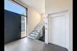 Step into modern luxury with this stunning entryway featuring a sleek dark gray door and expansive windows that flood the space with natural light.