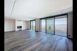 Experience breathtaking lake views from this spacious living area, featuring a modern fireplace and expansive sliding glass doors that open onto a private deck.