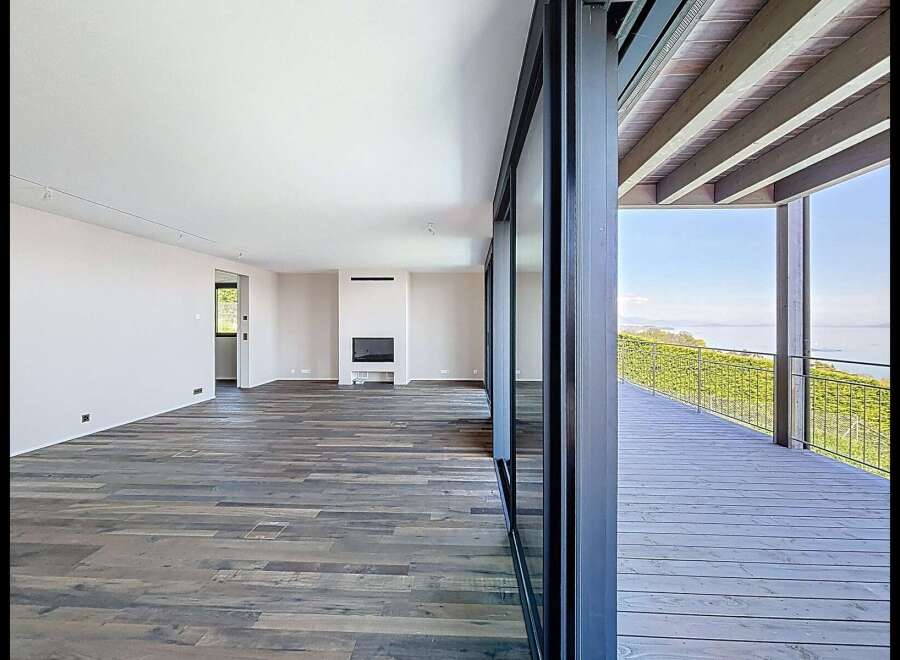 Experience modern living in this spacious open-plan room featuring a sleek fireplace and expansive glass doors.