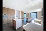 Experience modern luxury in this spacious open-plan kitchen featuring sleek wooden cabinetry and integrated appliances.