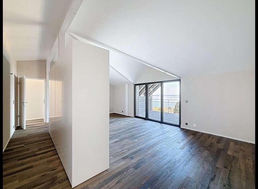 Experience breathtaking lake views from this stunning modern home featuring a spacious open-concept living area with vaulted ceilings and expansive glass doors.
