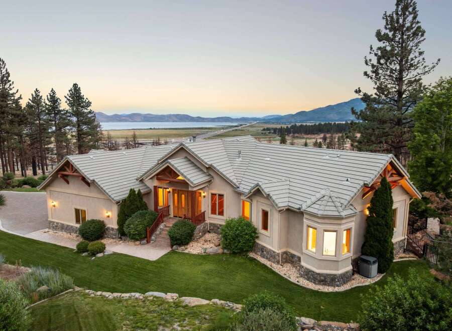 Experience luxury living in this stunning custom-built home, boasting panoramic views of the serene lake and majestic mountains.