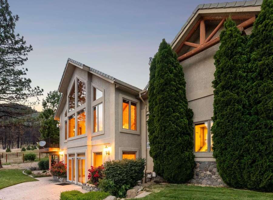 This stunning home features expansive, multi-story windows that capture breathtaking sunset views, creating a warm and inviting ambiance.