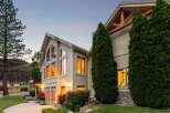 This stunning home features expansive, multi-story windows that capture breathtaking sunset views, creating a warm and inviting ambiance.