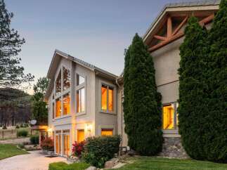 This stunning home features expansive, multi-story windows that capture breathtaking sunset views, creating a warm and inviting ambiance.