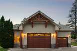 Experience rustic charm with this stunning home featuring a prominent wooden truss gable above a rich brown garage door.