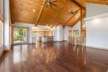 Experience luxurious living in this spacious open-concept home featuring a stunning vaulted wood-beam ceiling and gleaming hardwood floors.