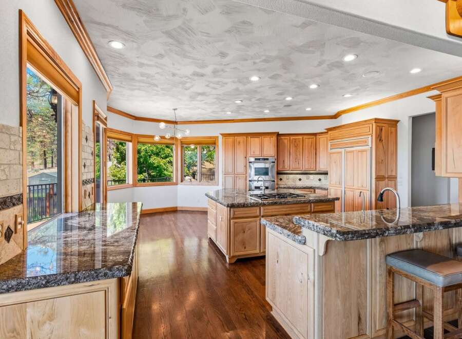 Experience luxury in this expansive kitchen, featuring custom wood cabinetry and gleaming granite countertops.
