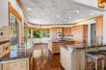 Experience luxury in this expansive kitchen, featuring custom wood cabinetry and gleaming granite countertops.