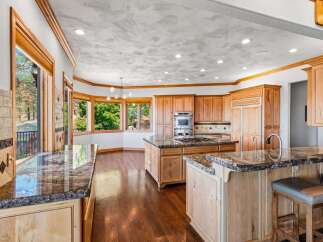 Experience luxury in this expansive kitchen, featuring custom wood cabinetry and gleaming granite countertops.
