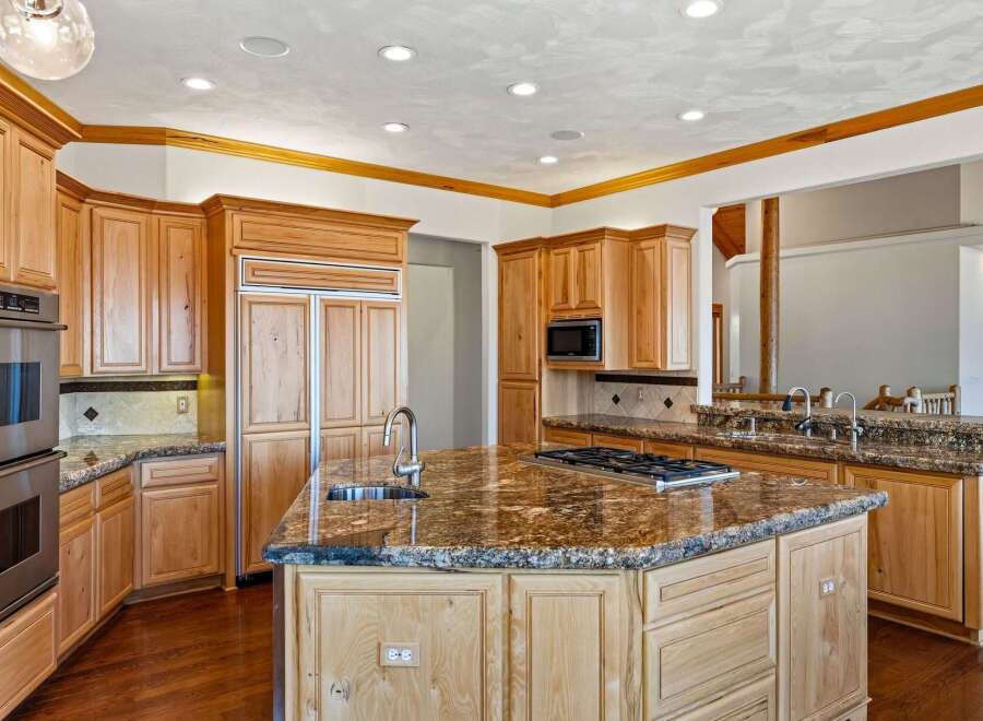 Experience luxury in this stunning kitchen, featuring custom light wood cabinetry and granite countertops.