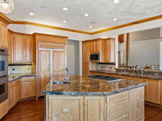 Experience luxury in this stunning kitchen, featuring custom light wood cabinetry and granite countertops.