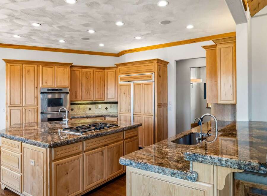 Experience luxury in this spacious kitchen featuring custom wood cabinetry and stunning granite countertops.