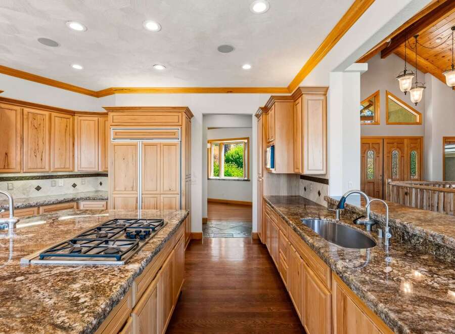 This spacious kitchen boasts custom wood cabinetry and granite countertops, perfect for any home chef.