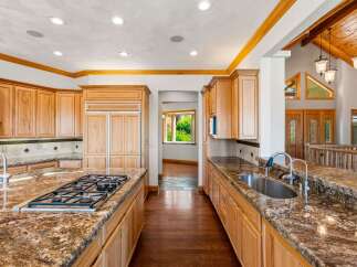 This spacious kitchen boasts custom wood cabinetry and granite countertops, perfect for any home chef.