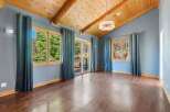 Experience breathtaking natural beauty from this stunning living space, featuring a vaulted wood-beamed ceiling and expansive windows that flood the room with natural light.
