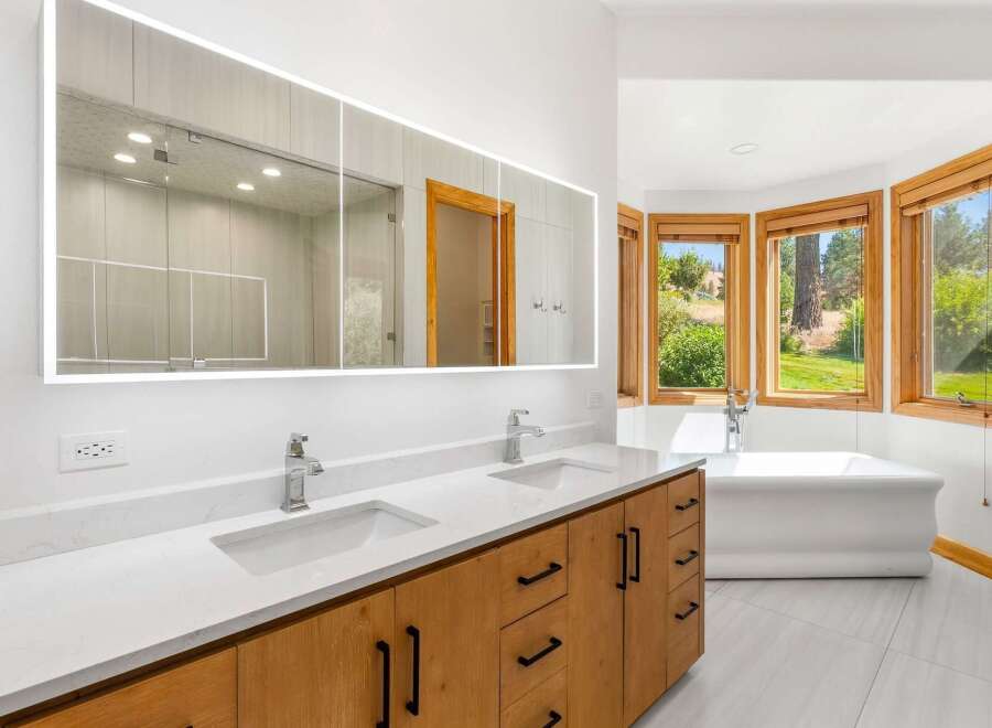 Experience luxury in this stunning bathroom featuring a spacious double vanity with sleek faucets and ample storage.