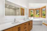 Experience luxury in this stunning bathroom featuring a spacious double vanity with sleek faucets and ample storage.
