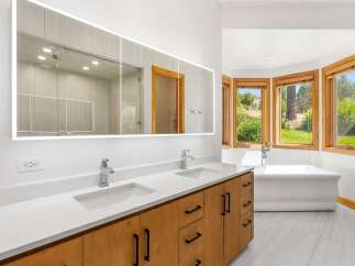 Experience luxury in this stunning bathroom featuring a spacious double vanity with sleek faucets and ample storage.