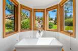 Indulge in ultimate relaxation in this stunning bathroom featuring a freestanding soaking tub perfectly positioned to capture breathtaking views.