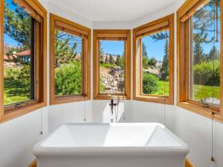 Indulge in ultimate relaxation in this stunning bathroom featuring a freestanding soaking tub perfectly positioned to capture breathtaking views.