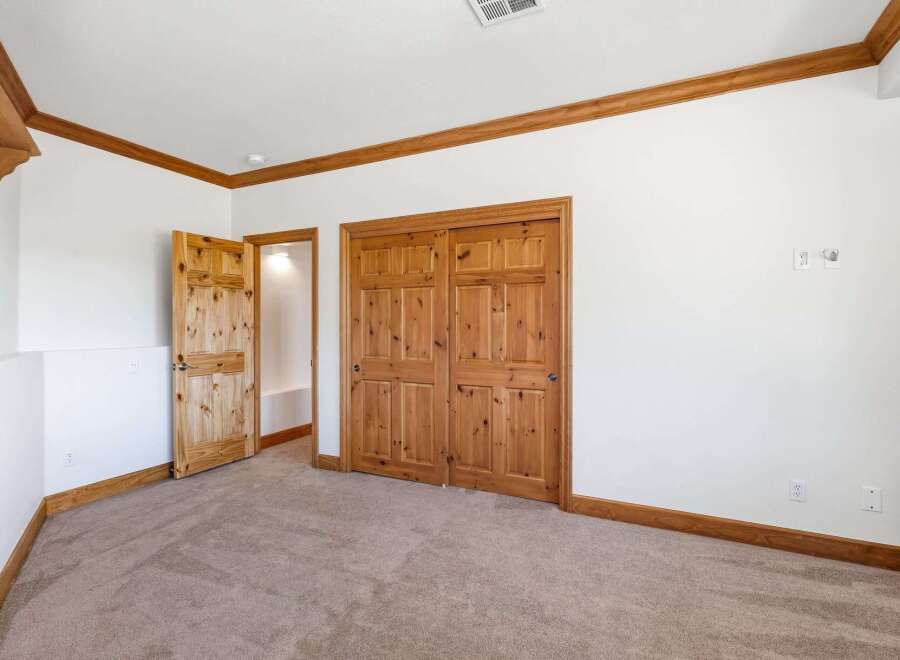 This bedroom features a warm and inviting atmosphere with its natural wood trim and doors.