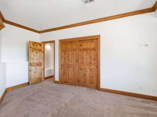 This bedroom features a warm and inviting atmosphere with its natural wood trim and doors.