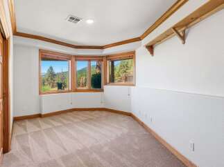 Experience breathtaking mountain views from this spacious room, featuring a charming bay window with rich wood trim.